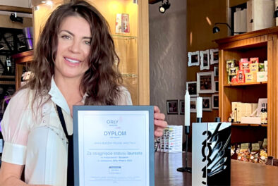 Projektant wnętrz Anna Buczny z pracowni Anna Buczny Piękne Wnętrza ze Szczecina, z nagrodą i dyplomem. Laureatka, wyróżniona w konkursie Orły Wnętrz z najwyższą oceną 10/10. Dyplom i nagrodę prezentuje we wnętrzu jednej ze szczecińskich restauracji.