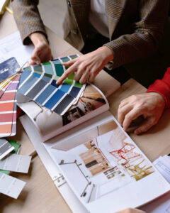 Architekt wnętrz Anna Buczny w pracowni wnętrz Anna Buczny PIękne Wnętrza w Szczecinie podczas spotkania z Klientami. Wszyscy siedzą przy stole i wybierają kolory farb i tkaniny do projektu wnętrz.